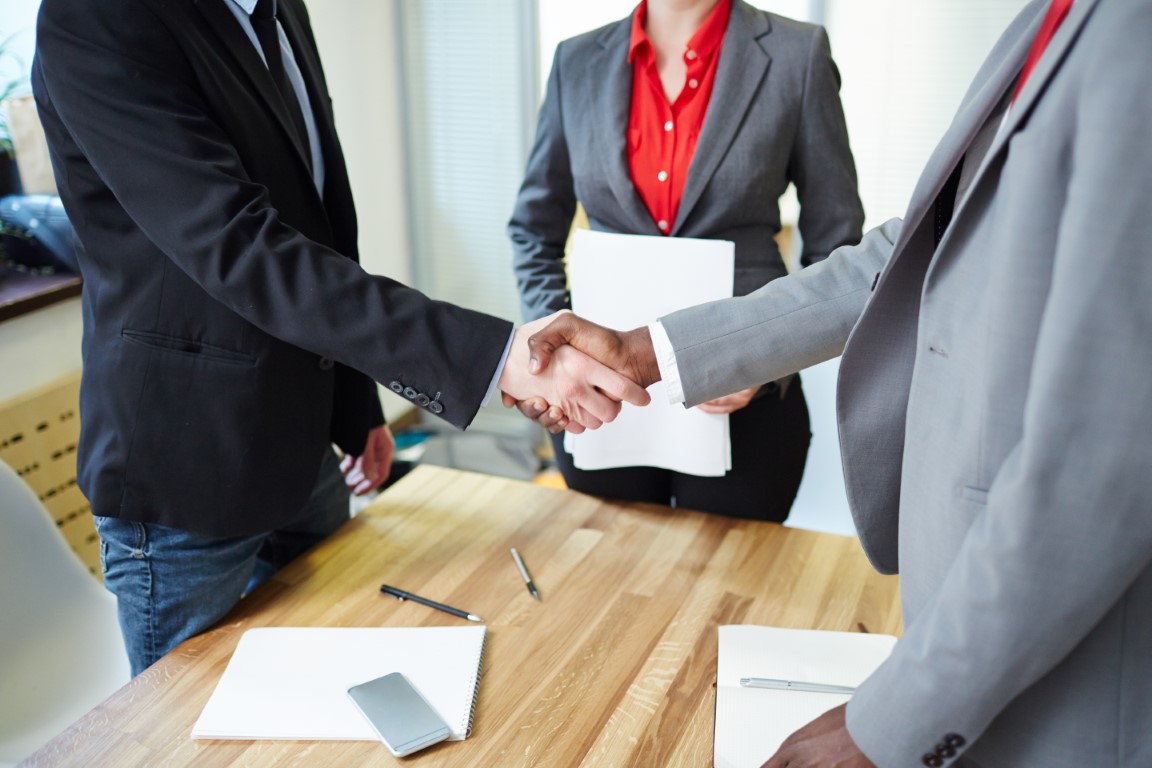 Successful business partners handshaking after signing contract